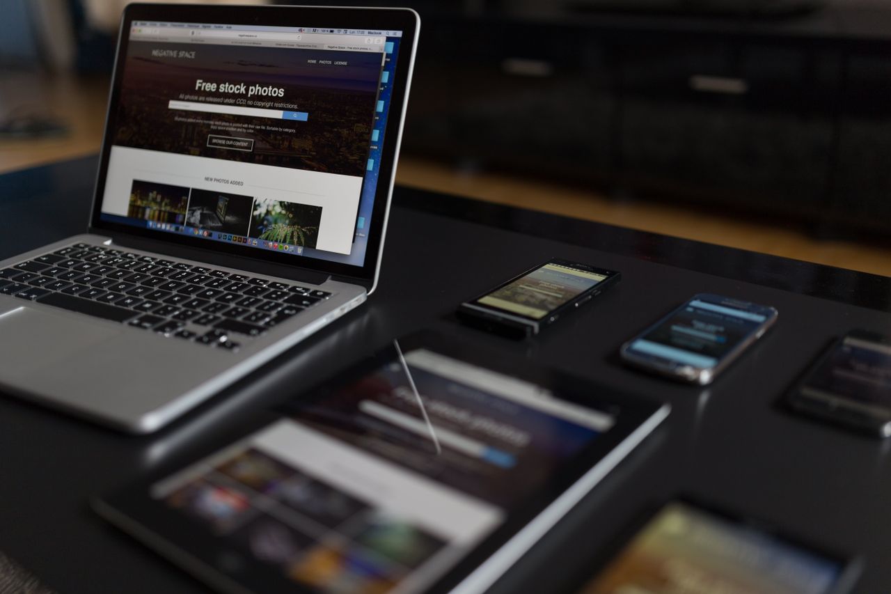 Un espace de travail moderne mettant en scène un ordinateur portable, une tablette et des smartphones, parfait pour un usage tech et freelance.